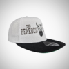White snapback cap with black peak featuring The Bearded Viking skull logo embroidery.